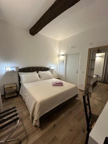 a bedroom with a large bed with white sheets at Il Glicine in Parma