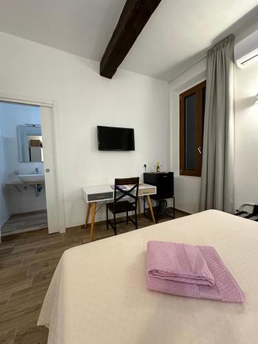 a bedroom with a bed and a table and a television at Il Glicine in Parma