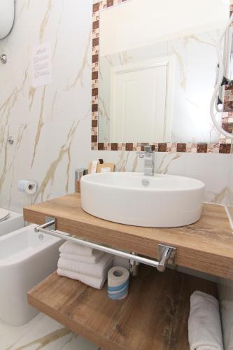 a bathroom with a sink and a mirror and a tub at AuRoom in Naples