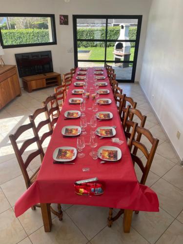 - une longue table avec des assiettes et des verres à vin dans l'établissement GÎTE PMR Morbihan, à Locmaria-Grand-Champ