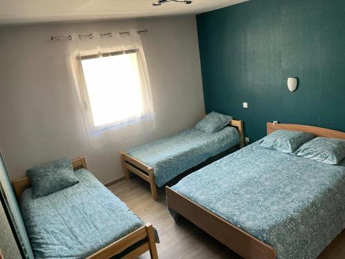 Cette chambre comprend 2 lits jumeaux et une fenêtre. dans l'établissement GÎTE PMR Morbihan, à Locmaria-Grand-Champ
