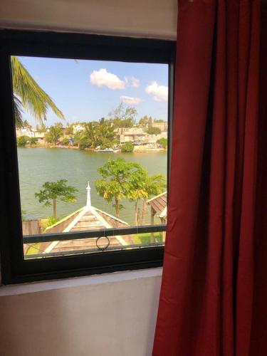 a window with a view of a river and a church at Lakeside Holidays in Pointe d'Esny