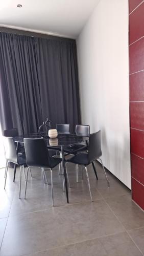 a dining room with a black table and chairs at My home in Sarzana in Sarzana
