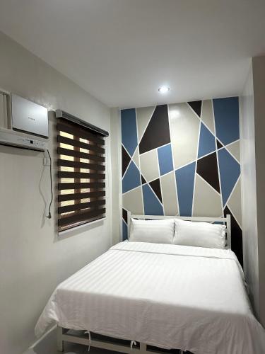 a bedroom with a large bed with a geometric wall at Calasiao Standard Room 2PAX in Dagupan