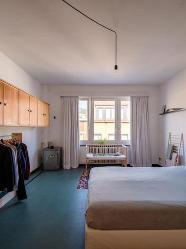 a bedroom with a bed and a bench in it at Art-deco woning Gent in Ghent