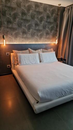 a large bed with white sheets and pillows at My home in Sarzana in Sarzana