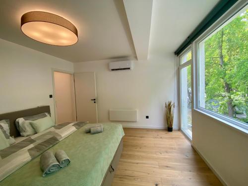 a bedroom with a bed and a large window at PS36 Holiday Home Siófok in Siófok