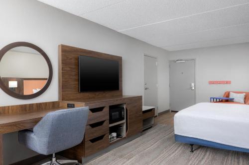 a bedroom with a bed and a desk and a mirror at Hampton Inn Louisville Airport Fair/Expo Center in Louisville