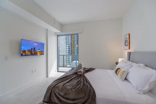 Un dormitorio blanco con una cama con una bolsa. en Condo with Amazing Views in the Heart of Brickell, en Miami