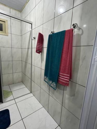 a shower stall with colorful towels on a wall at Pousada do Gil in Louro Müller