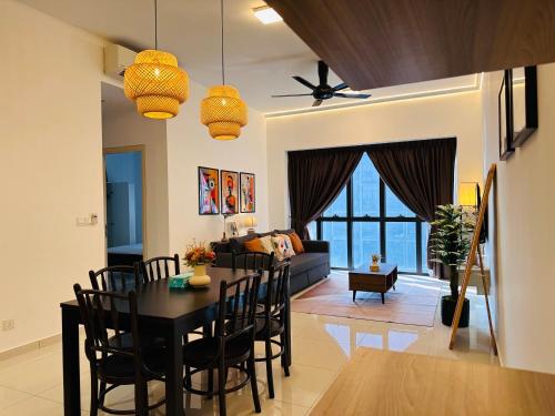 a dining room and living room with a table and chairs at Stylish Urban Oasis Icon City with Sky Pool and Cozy Interior in Petaling Jaya