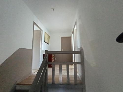 a staircase leading up to a room with white walls at La perle de Châteauneuf in Châteauneuf-du-Faou