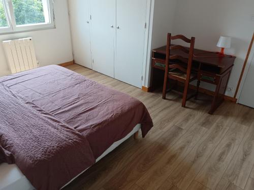 a bedroom with a bed and a desk and a chair at La perle de Châteauneuf in Châteauneuf-du-Faou