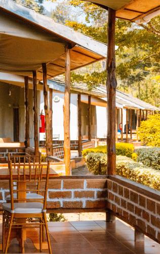 a patio with two chairs and a table at LUSHOTO EXECUTIVE LODGE in Lushoto