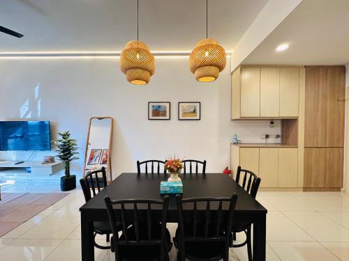 a kitchen and dining room with a black table and chairs at Stylish Urban Oasis Icon City with Sky Pool and Cozy Interior in Petaling Jaya