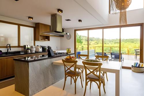 a kitchen with a table with chairs and a counter top at Casa Kai - Costa Dourada in Onça