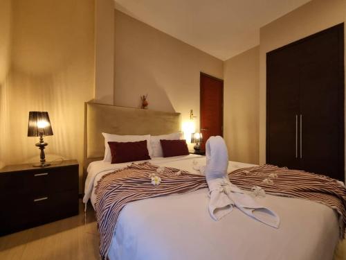 a bedroom with a bed with a pair of shoes on it at Rest Hub Poolvilla in Jomtien Beach