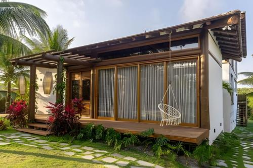 a small house with a porch and a swing at Casa Kai - Costa Dourada in Onça
