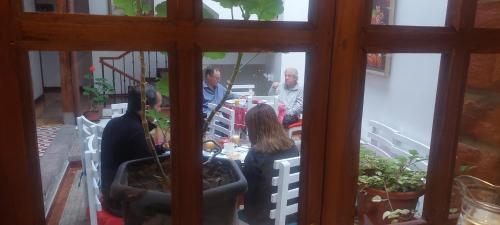 a group of people sitting at a table looking through a window at Hotel Casa Ecuatreasures Centro Historico in Quito