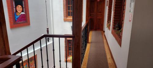 a stairway with a painting of a woman on a wall at Hotel Casa Ecuatreasures Centro Historico in Quito