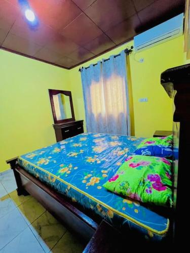 a bedroom with a bed with a blue comforter at Appartements meublés ACACIA Yaoundé in Yaoundé