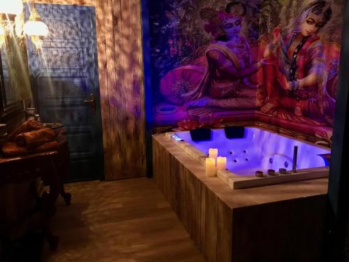 a bathroom with a tub with candles and a painting at SPA La Casa Blue in Wingles