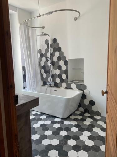 La salle de bains est pourvue d'une baignoire et d'un sol en damier. dans l'établissement Superbe appartement 2 chambres plein centre, à Ajaccio
