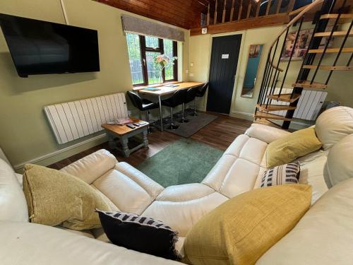 a living room with a white couch and a table at The Annexe at Gomo in East Winch
