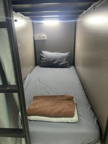 a small bed in a small room with a ladder at Meadows Hostel in Singapore