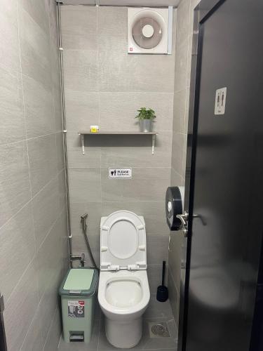a small bathroom with a toilet and a trash can at Meadows Hostel in Singapore