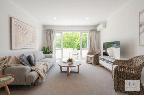 a living room with a couch and a tv at QV Stays Gorgeous Hideaway with Spanish Charm in Auckland