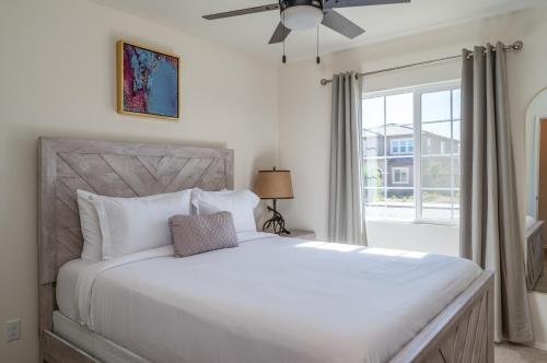a bedroom with a white bed and a window at Entertainers Paradise Luxe Pool With Game Room in Coachella