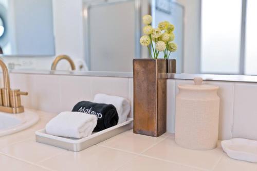 a bathroom with a sink and a vase with towels at Ridge Overlook | Stunning Mountain Views in Desert Hot Springs