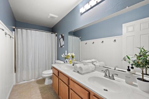 a bathroom with a sink and a toilet at Mirage Peak Manor Luxury Villa Pool Spa Games Hosted by Relaxtay in Casa Grande