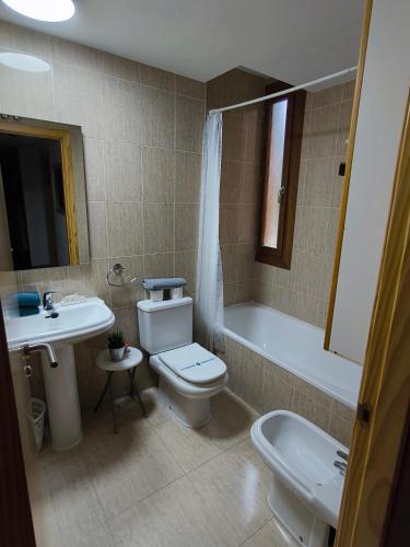 a bathroom with a toilet and a sink and a tub at Apartamento Diezcapanas in Villanúa