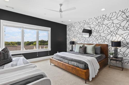 Un dormitorio con una cama y una ventana grande. en Walk to 12 South and Belmont with Garage FirePit and Patio, en Nashville