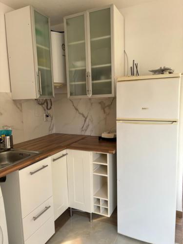 a kitchen with white cabinets and a white refrigerator at Herdade Palma T1p in Moita