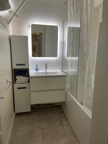 une salle de bain avec un lavabo, un miroir et une baignoire dans l'établissement Lisa V apart, à Cannes
