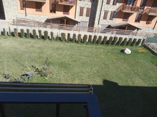 a blue bench in a yard with a building at APARTAMENTS CASA NANDO in Esterri d'Àneu