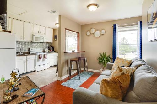 a living room with a couch and a kitchen at Walkable Apt Near Kentucky Derby! in Louisville