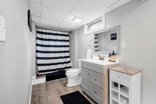 a white bathroom with a toilet and a sink at Lucky 8 Camp Cozy Coastal Retreat with Hidey Hole & Family Charm in Waterford