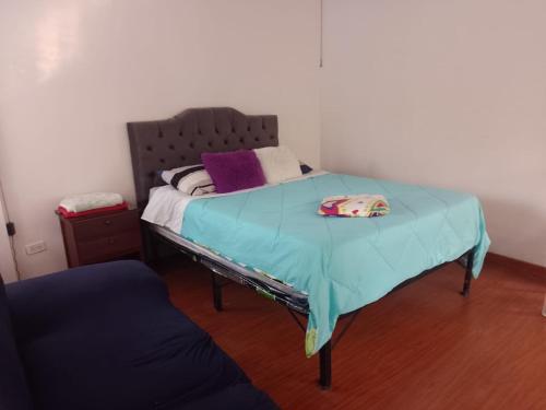 a bed with a blue blanket on top of it at Claro de Luna in San Francisco