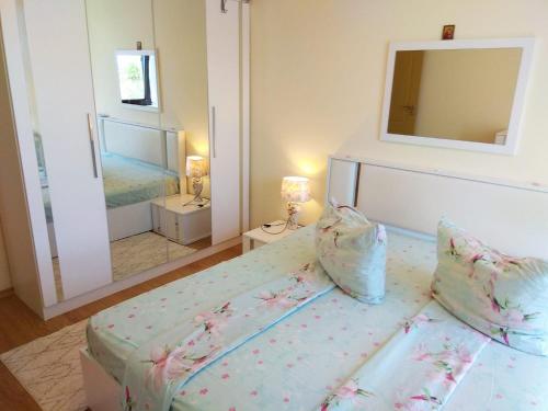 Un dormitorio con una cama y un espejo grande. en Прекрасный апартамент с видом на море и бассейном, en Byala