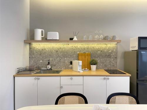 a kitchen with a counter with a sink and a refrigerator at Vélin Khaosan - 2nd Floor apartment with 2Bedrooms in Bangkok