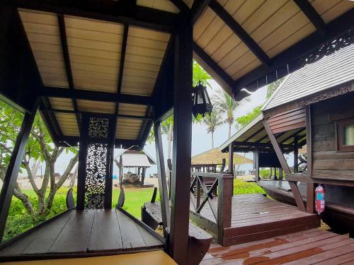 a porch of a house with a wooden deck at Baan Thong Ching Resort in Khanom