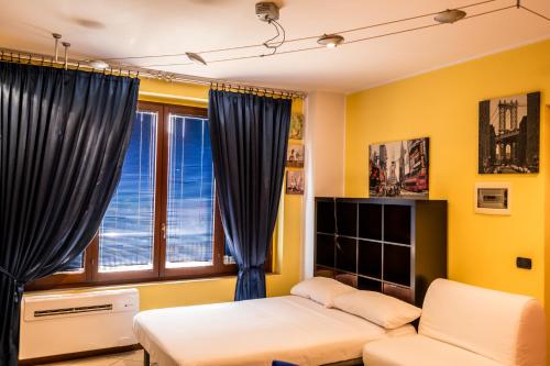 a living room with a couch and a window at Cozy Suite Rogoredo Apartment next to the metro and train station in Milan