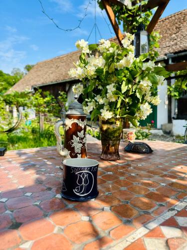 a coffee mug sitting on a table with flowers at Saschiz 130/Lodging and Glamping in Saschiz
