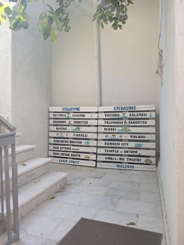 a wall of stairs withcriptions on it in a room at Katerina's Apartment in Ancient Epidauros
