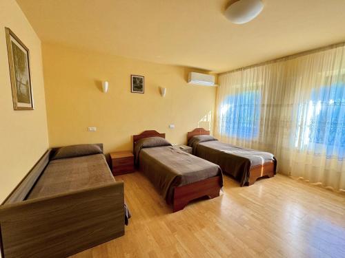 a room with three beds and a window at Alloggio Agrituristico Ronchi Di Fornalis in Cividale del Friuli