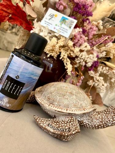 a bottle of essential oil next to a plate and flowers at Breeze Home in Vlorë